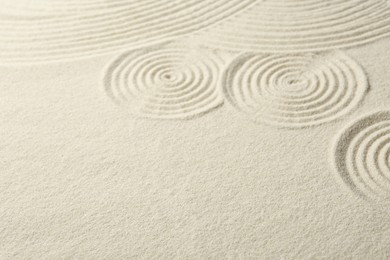 Photo of Zen rock garden. Circle patterns on beige sand