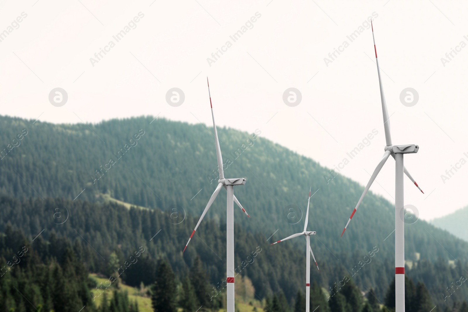 Image of Alternative energy source. Wind turbines and mountains outdoors 