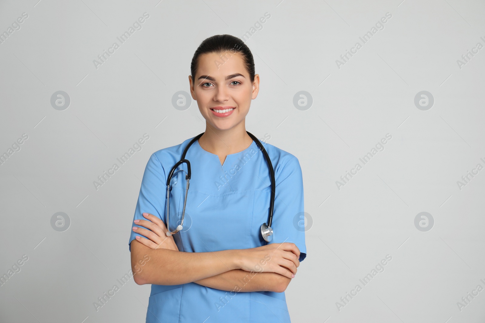 Photo of Portrait of young medical assistant with stethoscope on color background