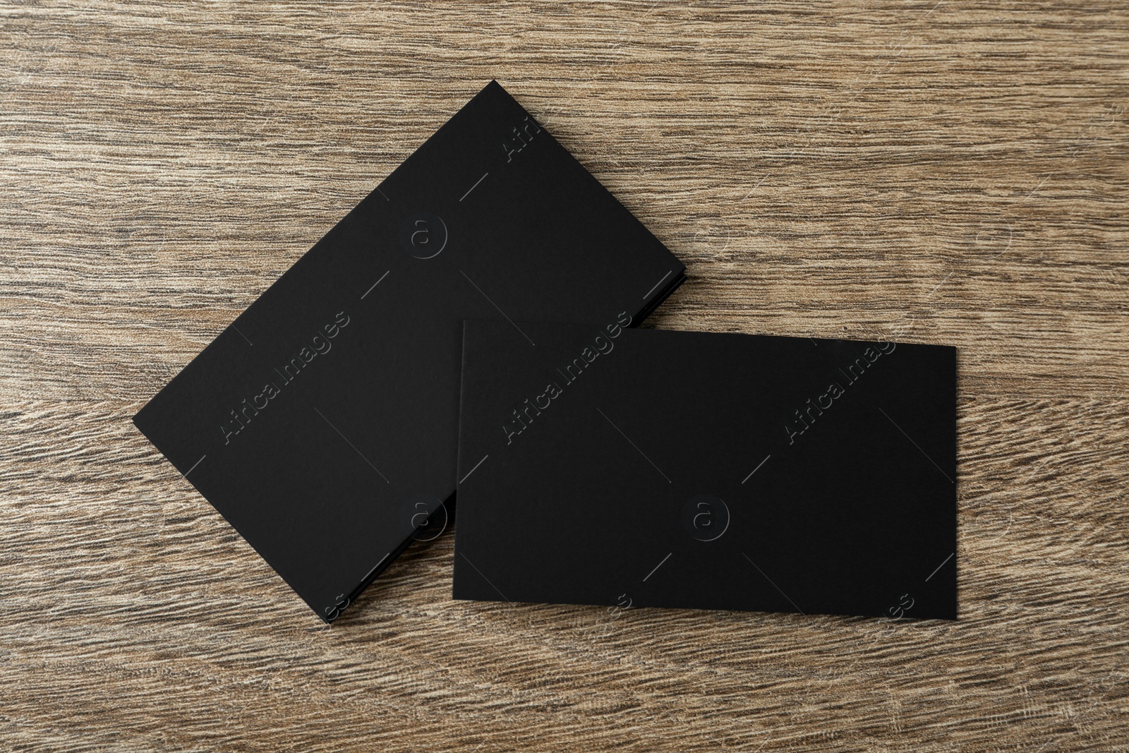 Photo of Blank black business cards on wooden background, flat lay. Mockup for design