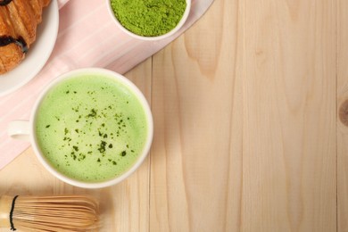 Flat lay composition with tasty matcha latte on wooden table, space for text