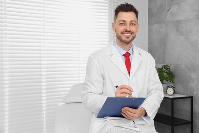 Happy doctor with clipboard in clinic, space for text. Patient consultation