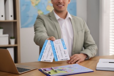 Photo of Travel agent with tickets at table in office, closeup