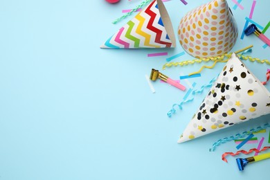 Photo of Flat lay composition with party hats and other festive items on light blue background. Space for text