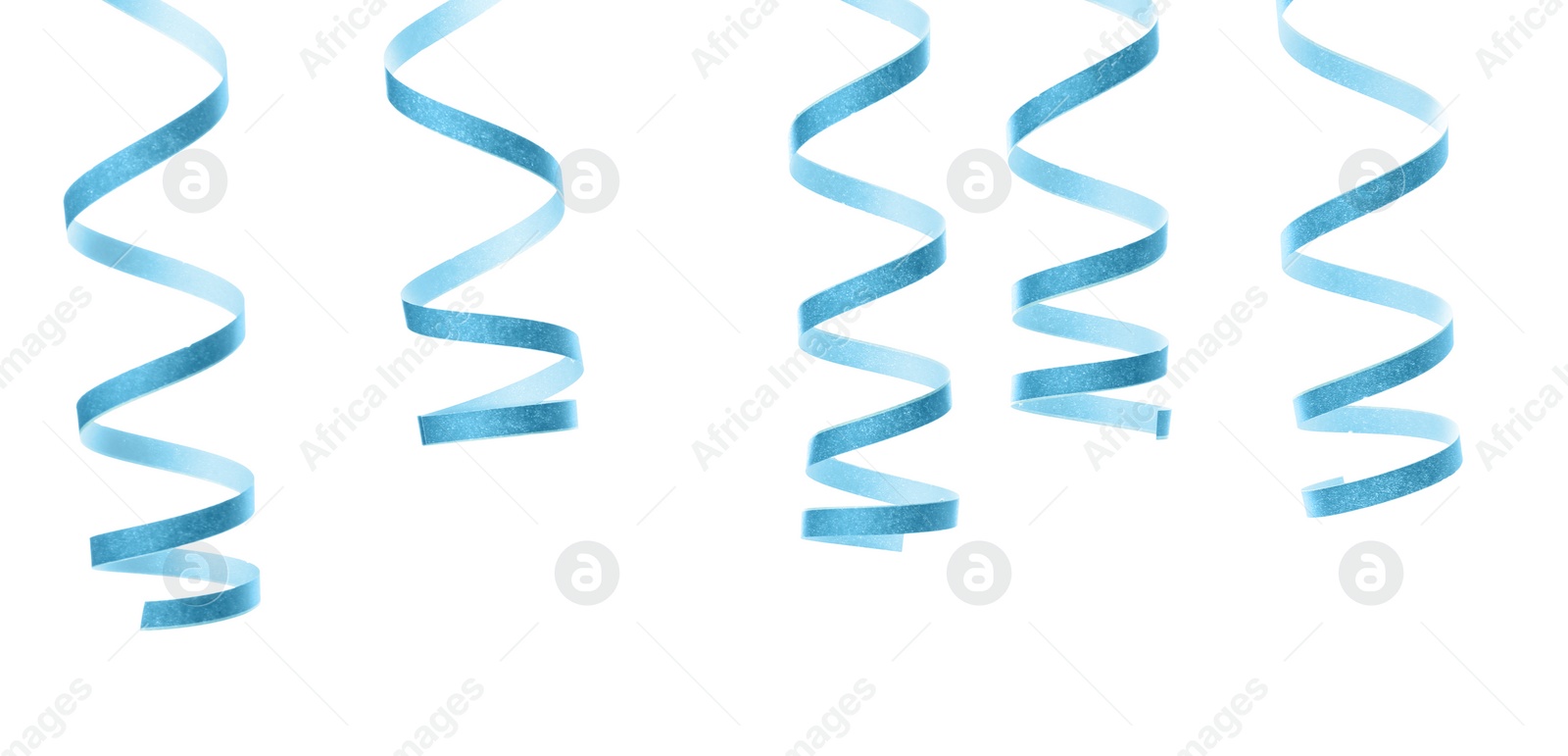 Photo of Light blue serpentine streamers on white background. Festive decor