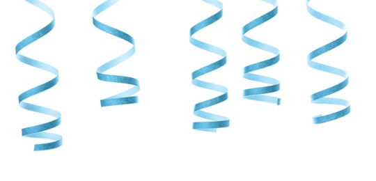 Light blue serpentine streamers on white background. Festive decor