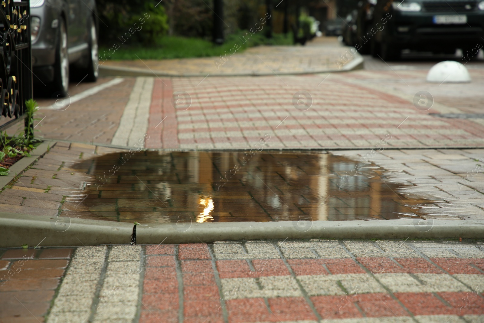 Photo of Puddle after rain on street tiles outdoors