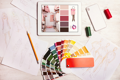 Image of Modern designer's workplace with tablet and color palette samples on wooden table , flat lay 