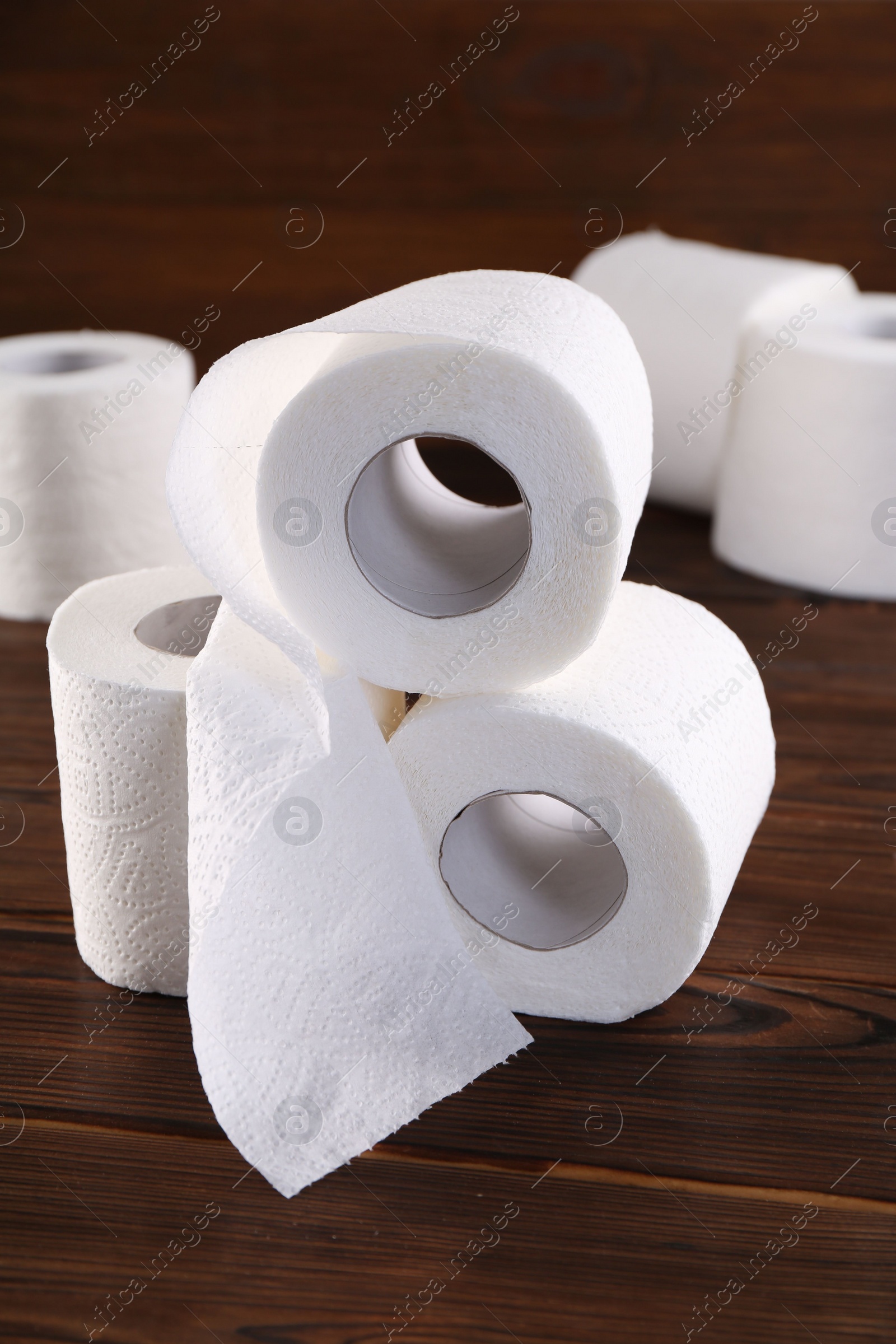 Photo of Many soft toilet paper rolls on wooden table