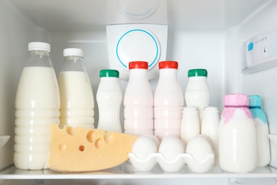 Photo of Open refrigerator with many different products, closeup