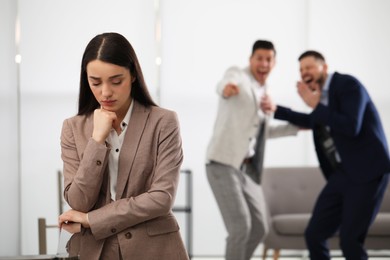 Photo of Coworkers bullying their colleague in office, space for text
