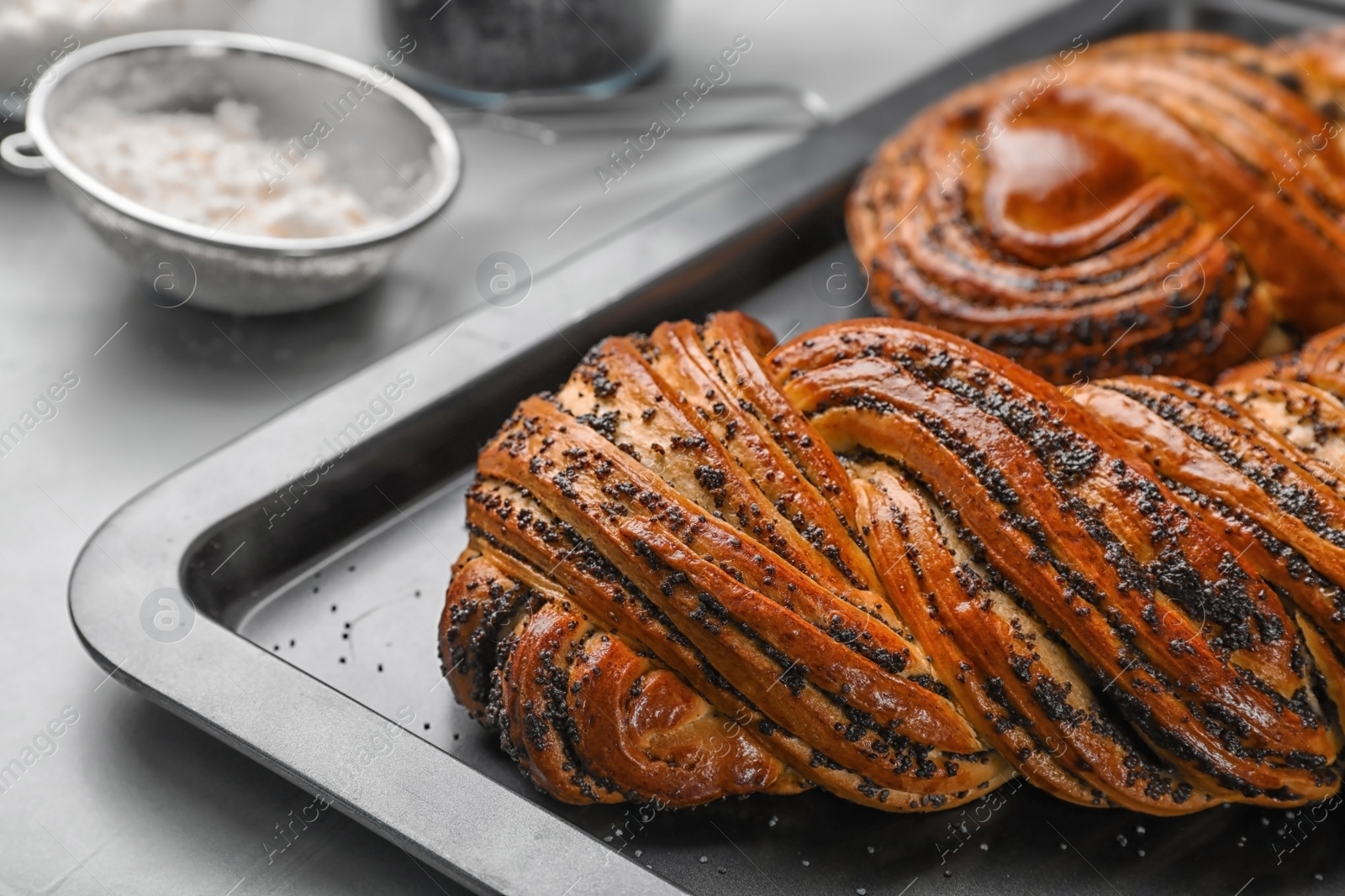 Photo of Tasty sweet buns with poppy seeds on gray table