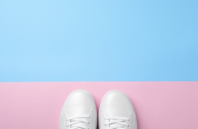 Pair of sneakers on color background, flat lay. Space for text