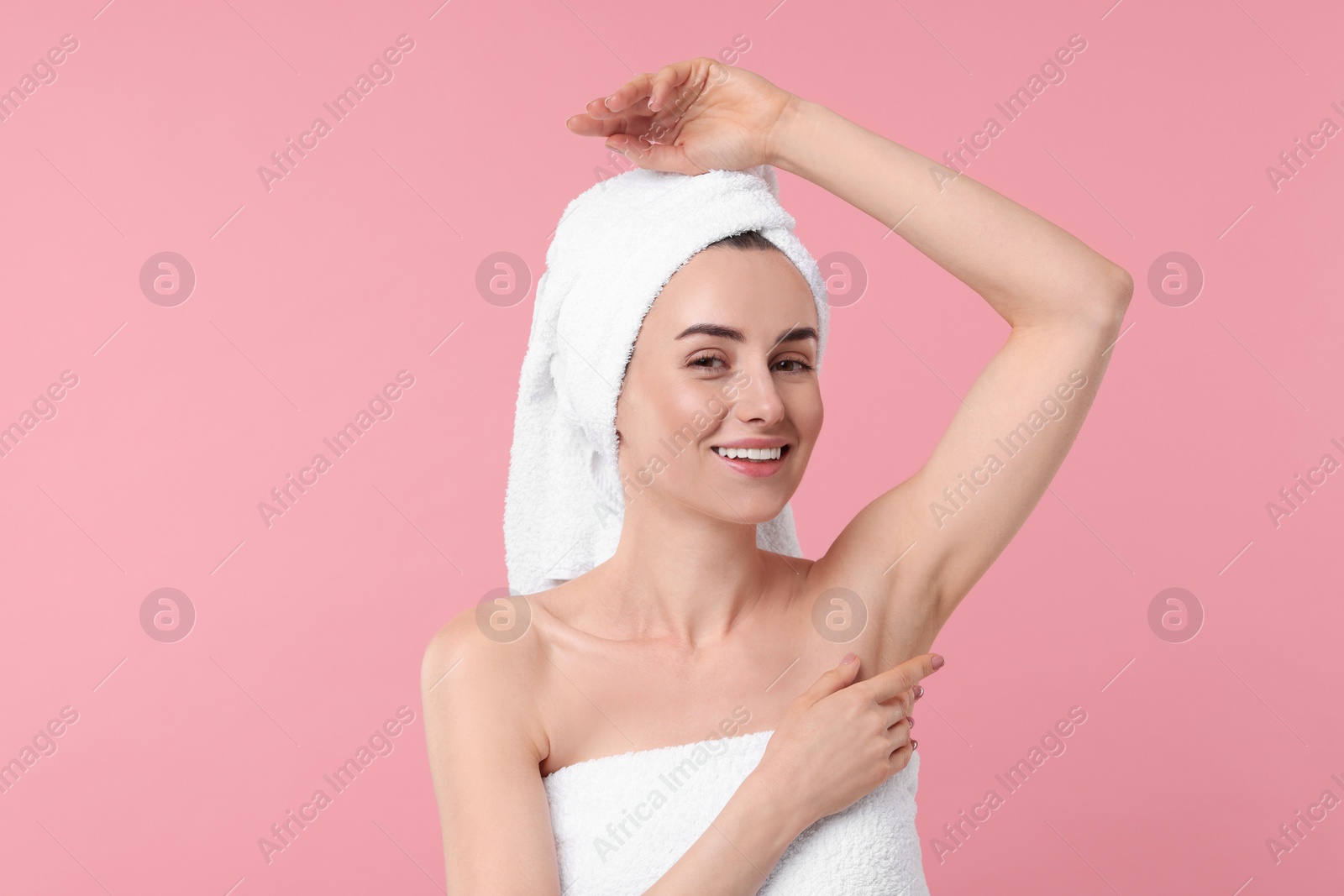 Photo of Beautiful woman showing armpit with smooth clean skin on pink background