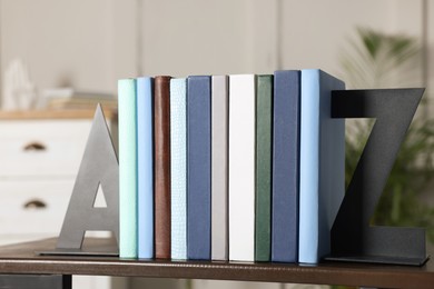 Photo of Minimalist letter bookends with books on shelf indoors
