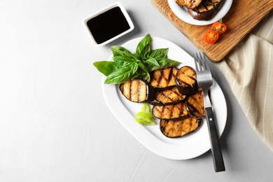 Photo of Plate with fried eggplant slices on table, top view. Space for text