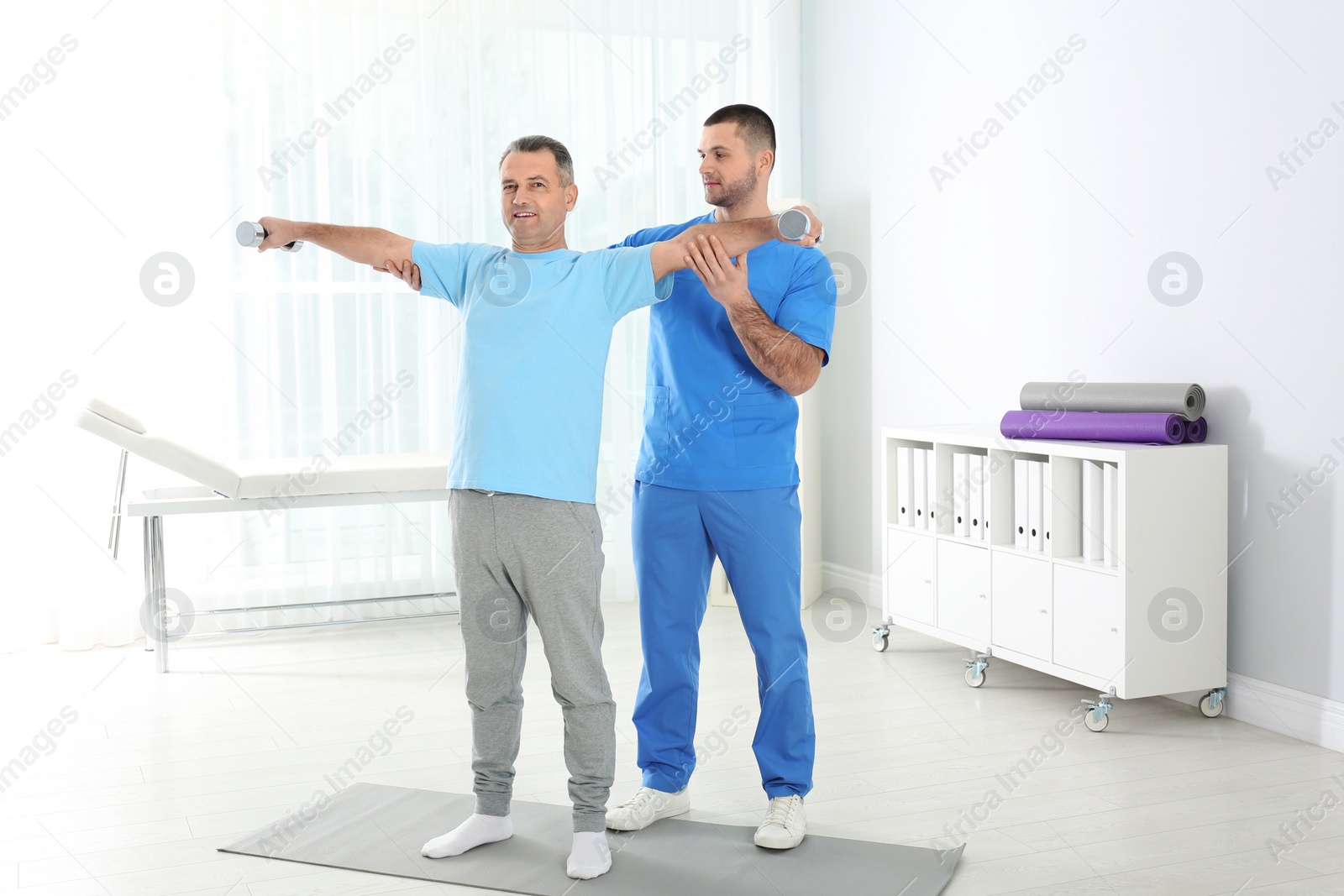 Photo of Doctor working with patient in hospital. Rehabilitation exercises