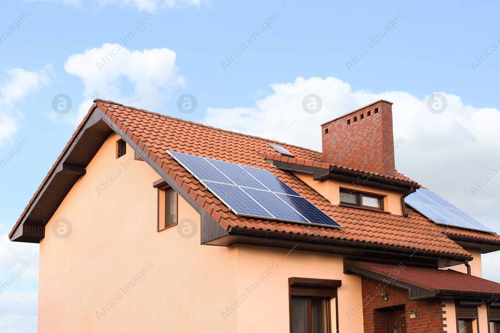 Photo of House with installed solar panels on roof. Alternative energy