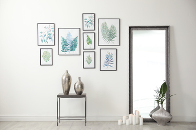 Living room interior with paintings of tropical leaves on white wall