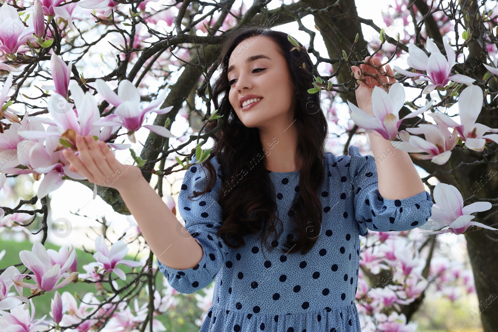 Photo of Beautiful woman near blossoming magnolia tree on spring day