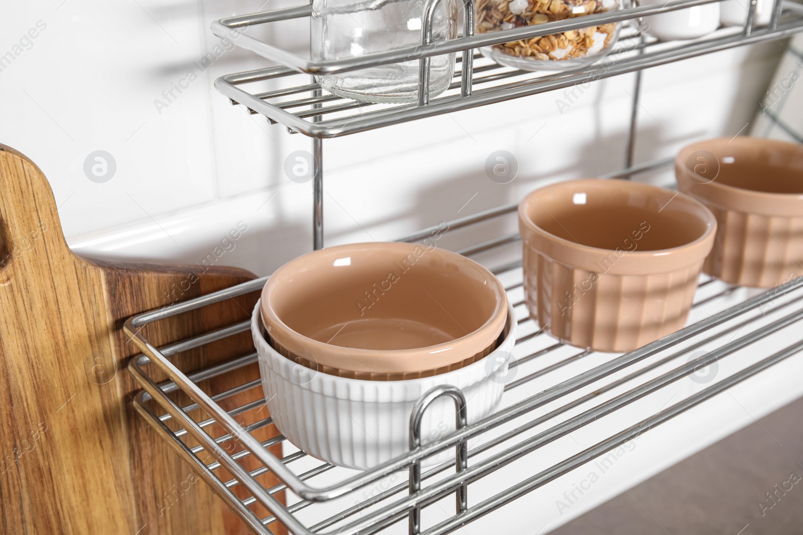 Photo of Many different ramekins on metal rack in kitchen