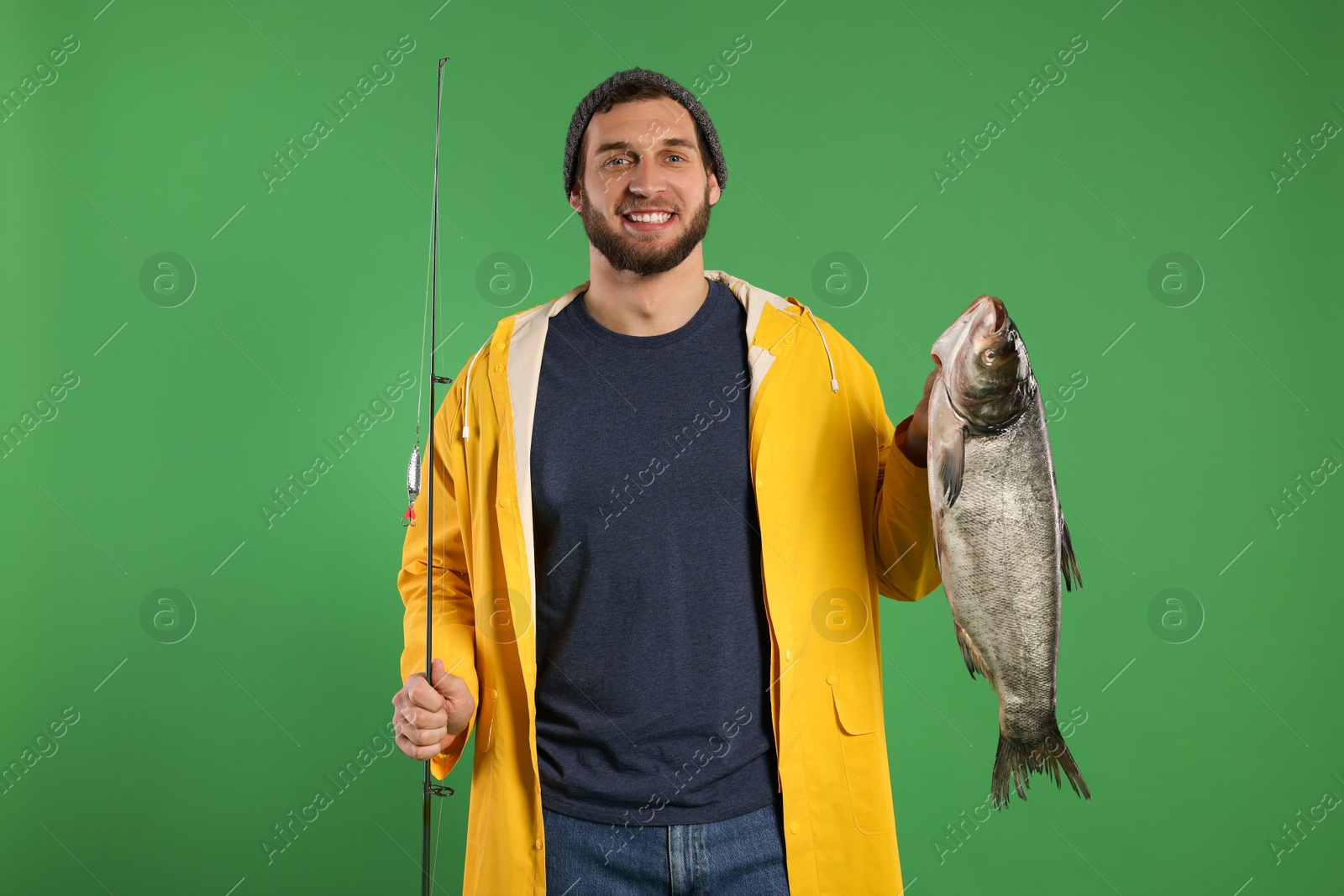 Photo of Fisherman with rod and catch on green background