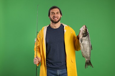 Photo of Fisherman with rod and catch on green background