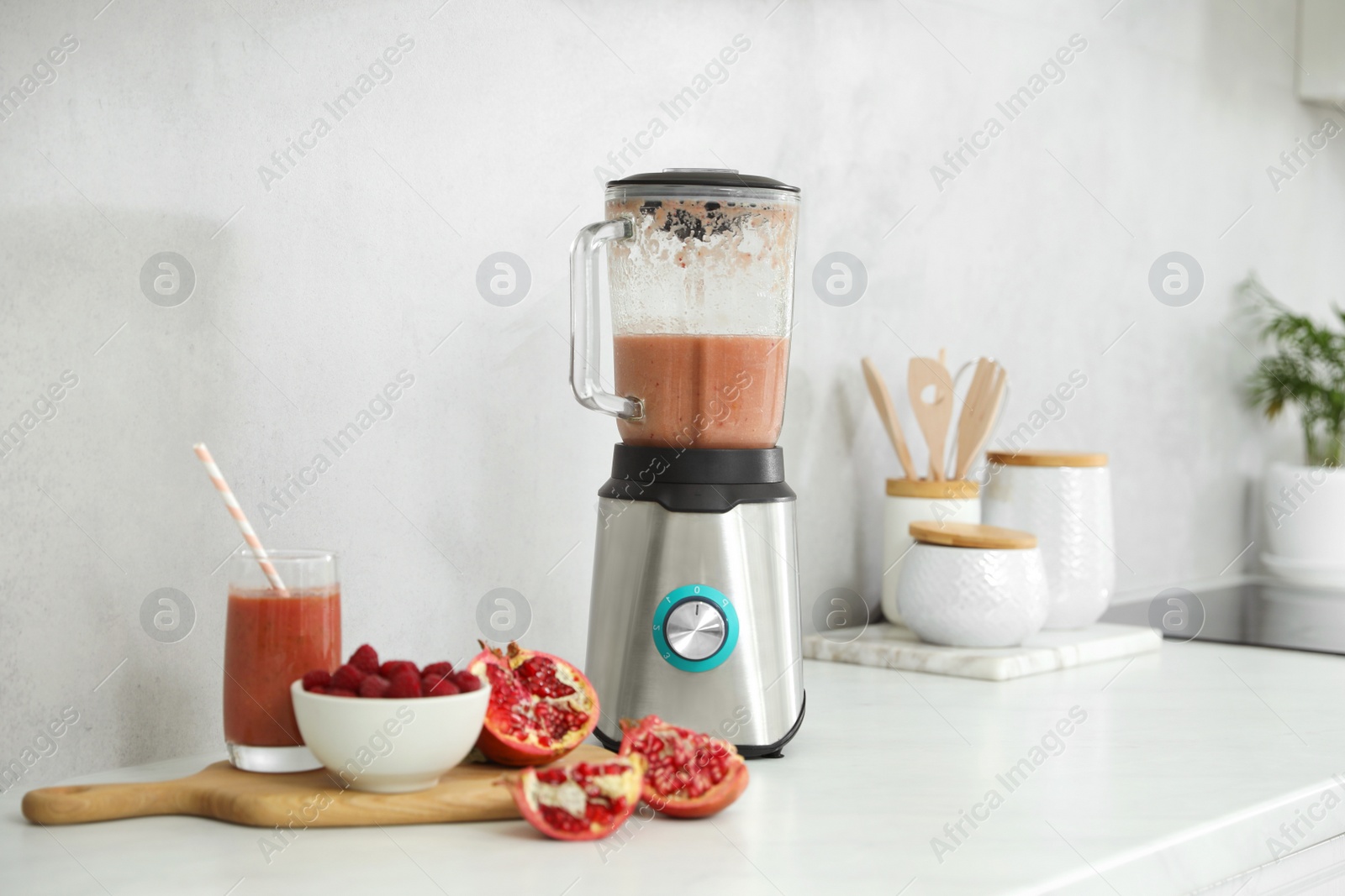 Photo of Blender and smoothie ingredients on white countertop in kitchen