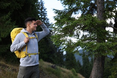 Photo of Tourist with backpack in forest, space for text