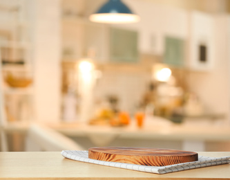 Image of Towel and cutting board on wooden table in kitchen. Space for text