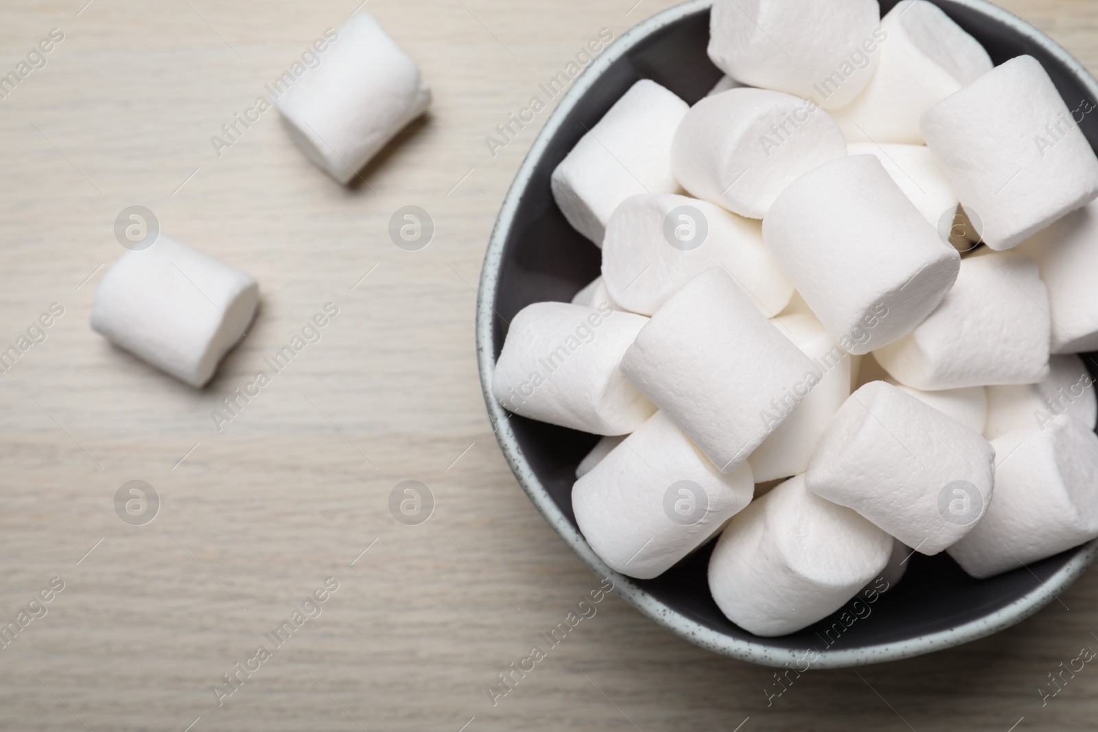 Photo of Delicious puffy marshmallows on wooden table, flat lay