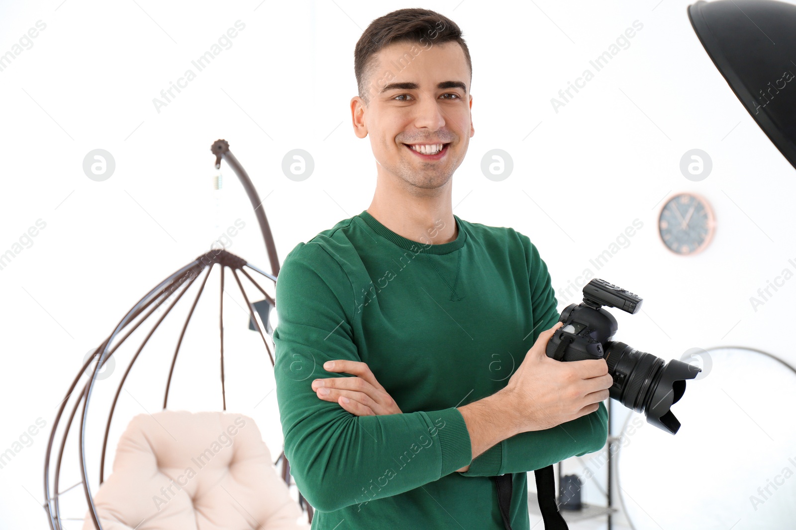 Photo of Young photographer with professional camera in studio
