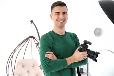 Photo of Young photographer with professional camera in studio