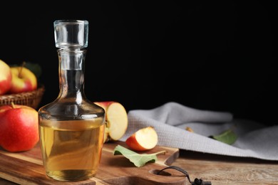 Photo of Natural apple vinegar and fresh fruits on wooden table. Space for text