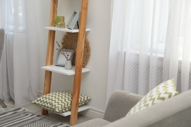 Photo of Stylish living room interior with wooden ladder near white wall