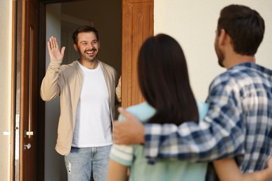 Photo of Friendly relationship with neighbours. Young couple visiting happy man