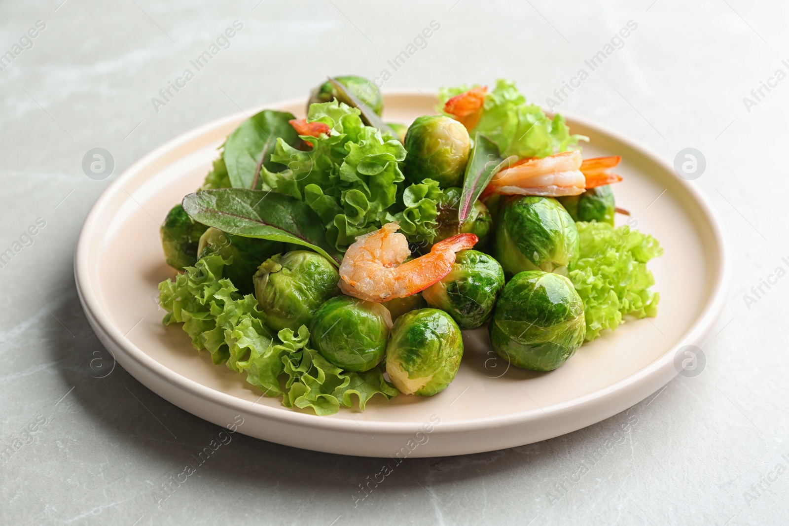 Photo of Tasty salad with Brussels sprouts on light grey table