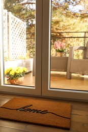 Photo of Doormat with word Home on parquet floor indoors