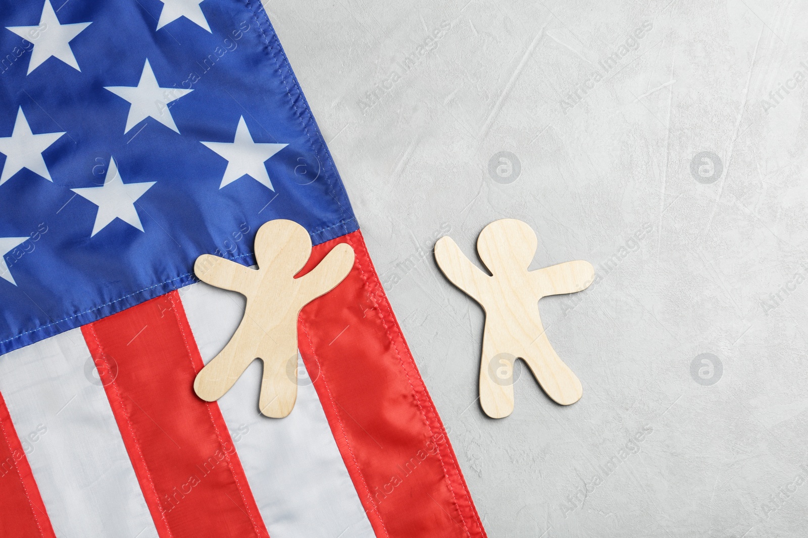 Photo of Flat lay composition with wooden people and USA flag on light background