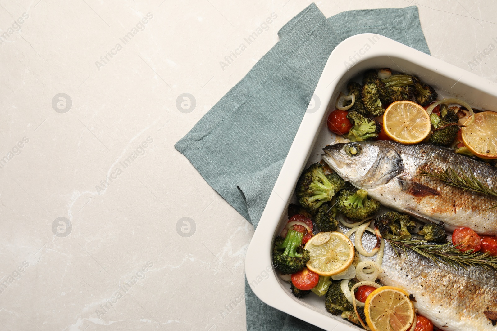 Photo of Delicious fish with vegetables and lemon in baking dish on light marble table, top view. Space for text