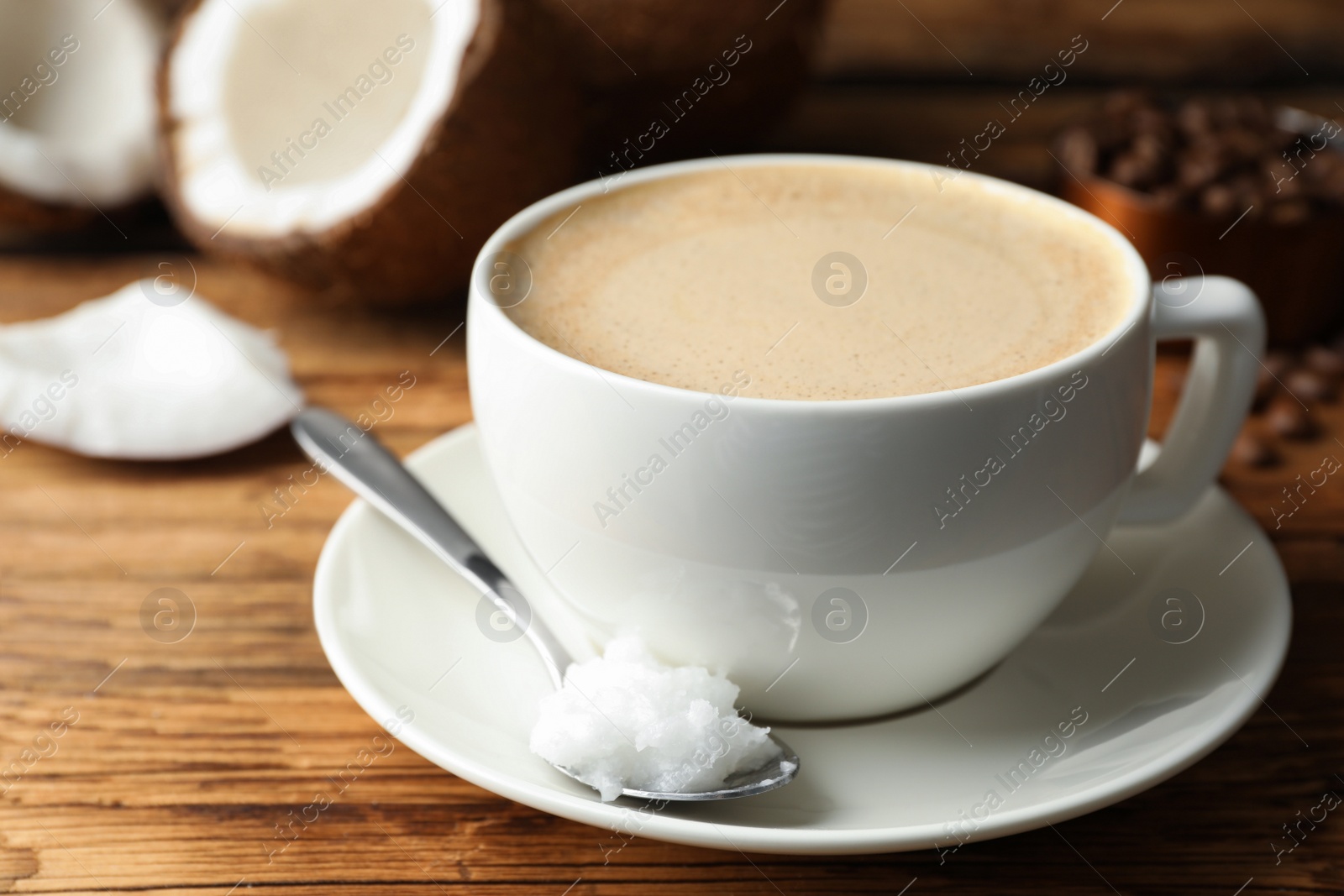 Photo of Delicious coffee with organic coconut oil on wooden table