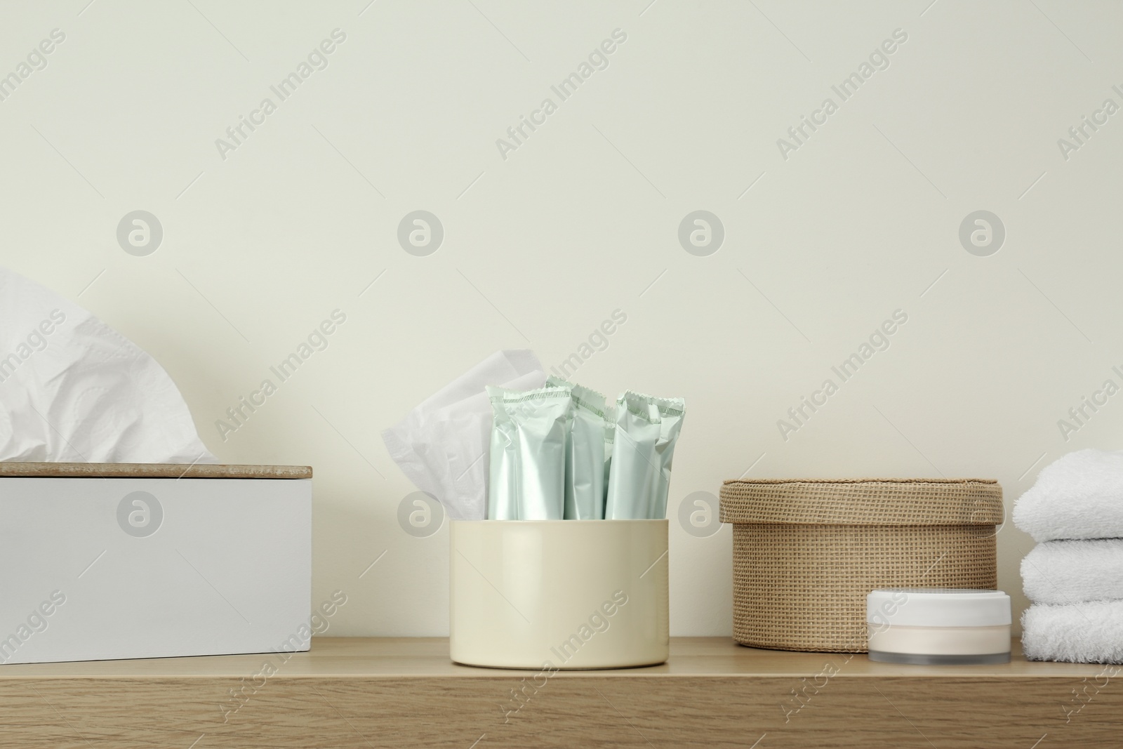 Photo of Different feminine and personal care products on wooden shelf