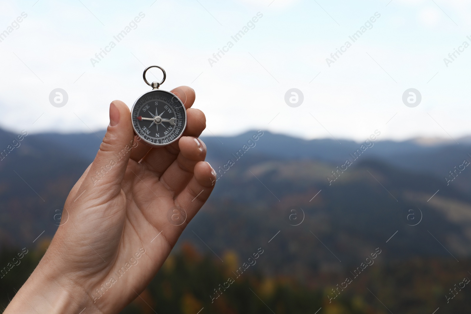 Photo of Woman using compass during journey in mountains, closeup