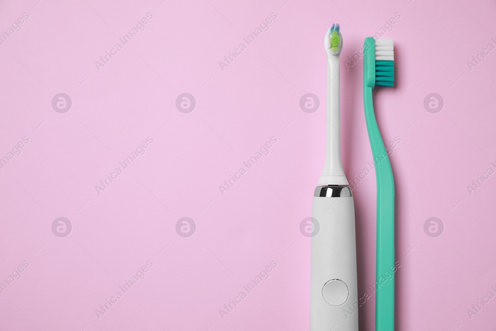 Photo of Electric and plastic toothbrushes on pink background, flat lay. Space for text