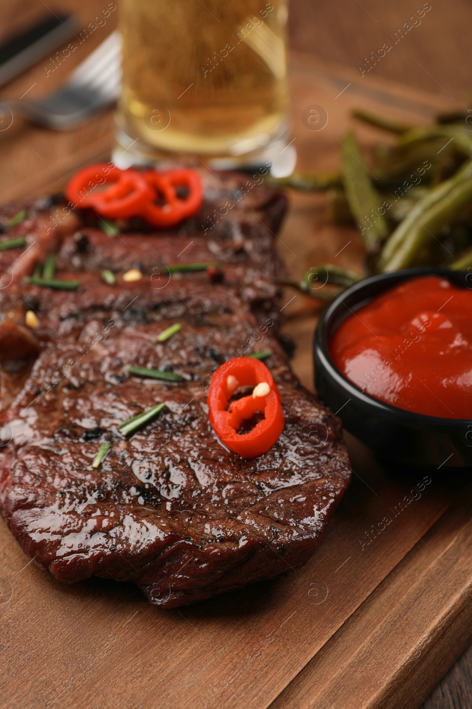 Photo of Delicious fried steak and sauce on wooden table, closeup