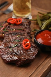 Photo of Delicious fried steak and sauce on wooden table, closeup