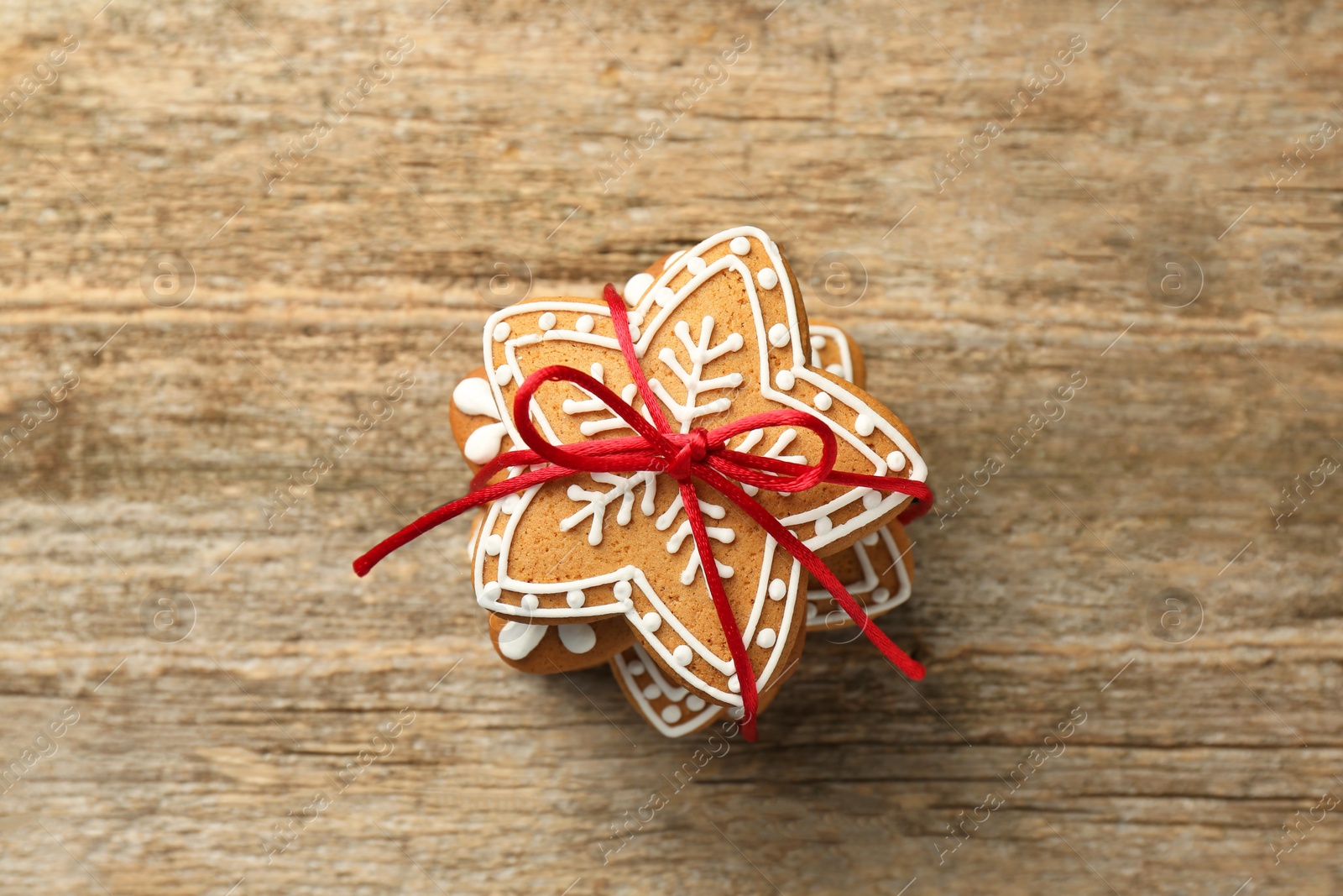 Photo of Tasty Christmas cookies with icing on wooden table, top view