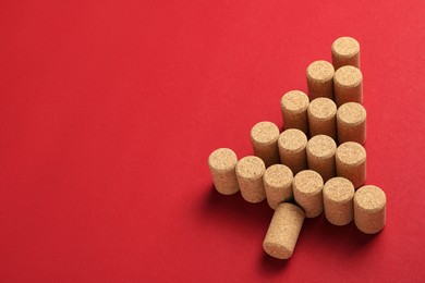 Photo of Christmas tree made of wine corks on red background. Space for text