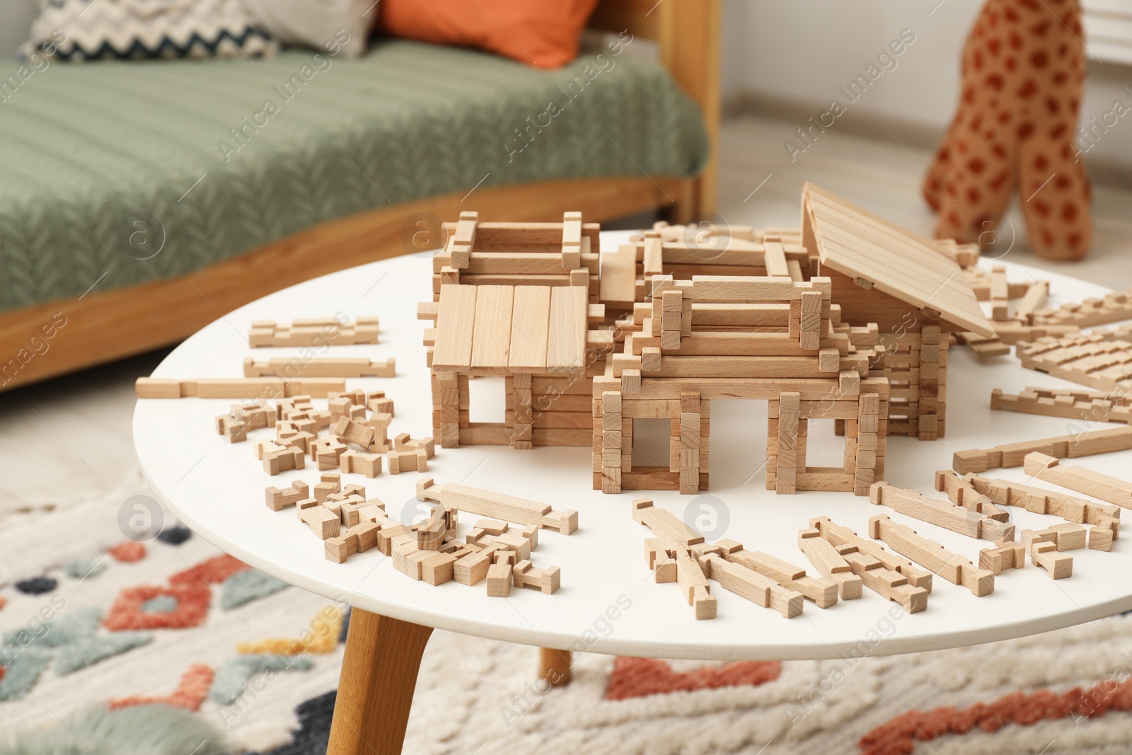 Photo of Wooden construction set on white table indoors. Children's toy