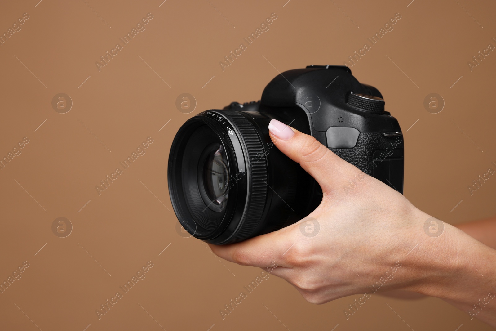 Photo of Photographer with camera on brown background, closeup. Space for text